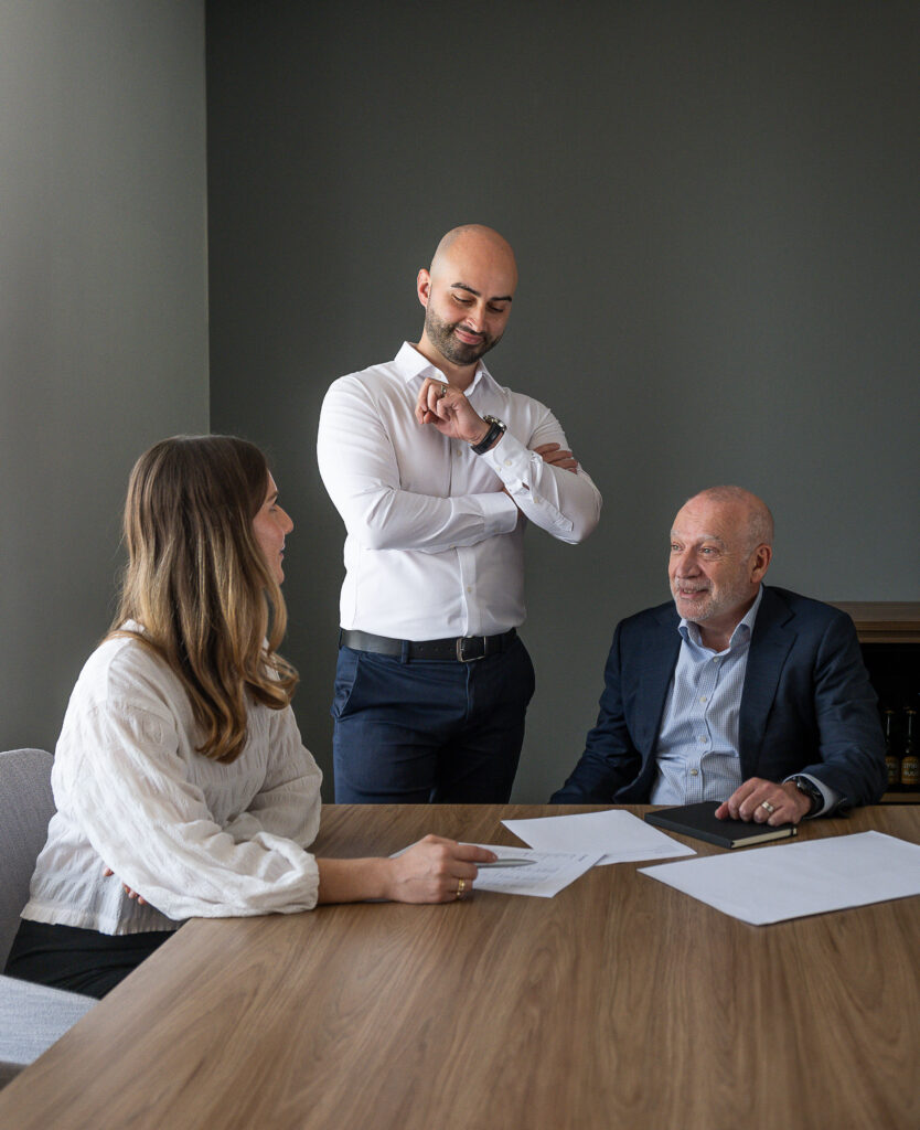 three advisors in a meeting room with papers on the table